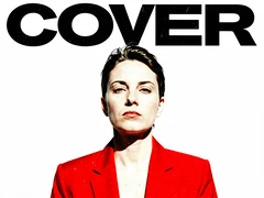 A person in a bold red blazer posed against a flat white studio backdrop, chin slightly raised, looking directly at the camera with a composed expression. The word "COVER" in large black block capitals sits at the top of the frame. Hard front-facing studio strobe light, zero fill, pure white background with no gradients. Atmosphere is editorial and confrontational. Raw photocopy zine aesthetic, brutalist DIY print energy with high-contrast pure white #FFFFFF and pure black #000000, disrupted by aggressive red #FF0000 accents and muted grey #F2F2F2 mid-tones. Flat hard daylight with crushed shadows and no soft falloff. Style: brutalist zine. Mood: confrontational.